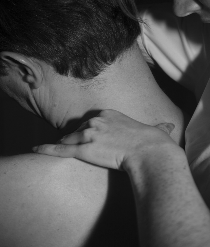 A Massage Therapist Rubbing the Back of a Man’s Neck