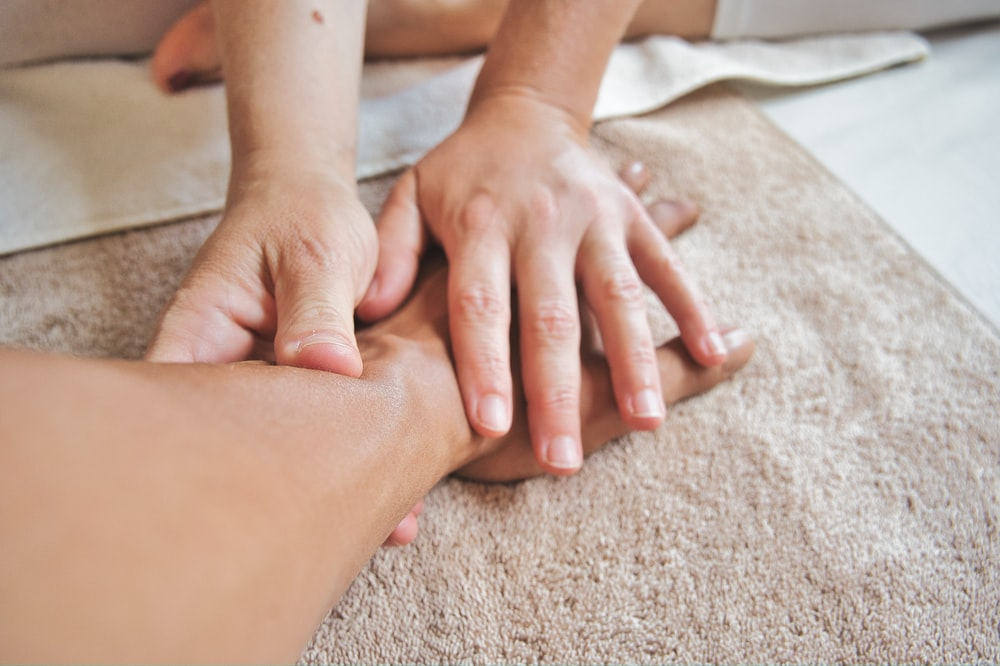 A Faceless Massage Therapist Rubbing a Faceless Man’s Forearm