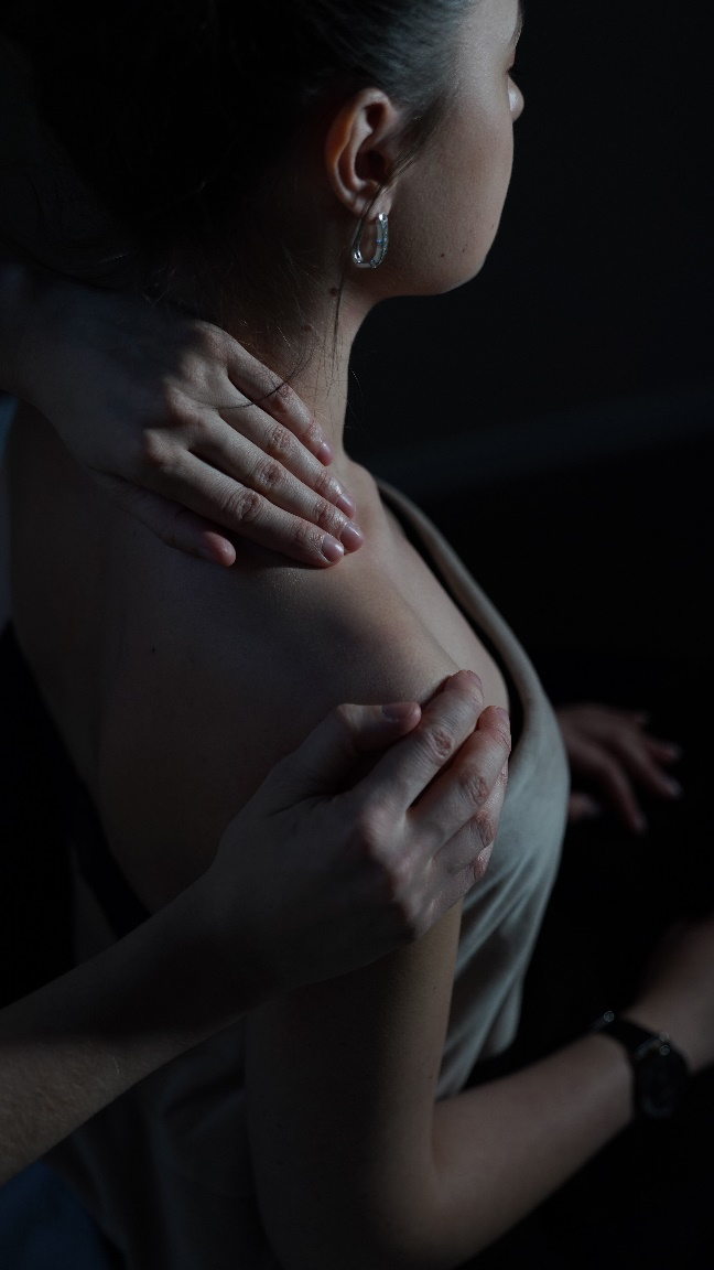 A woman getting a back massage in a dimly-lit room