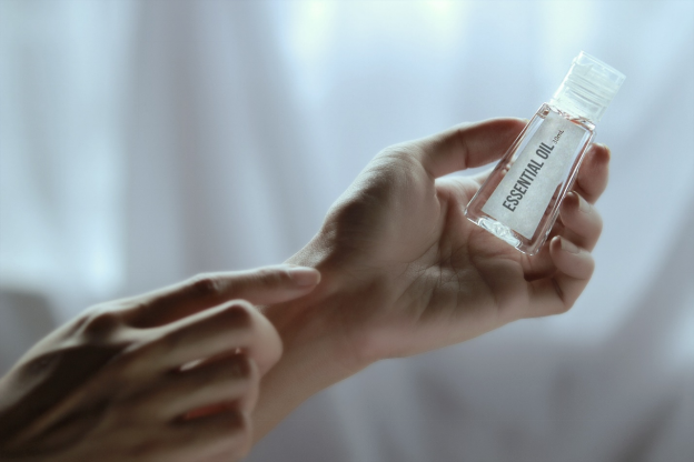  A massage therapist holding a bottle of essential oil