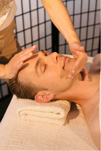  A man getting a facial massage during massage therapy session