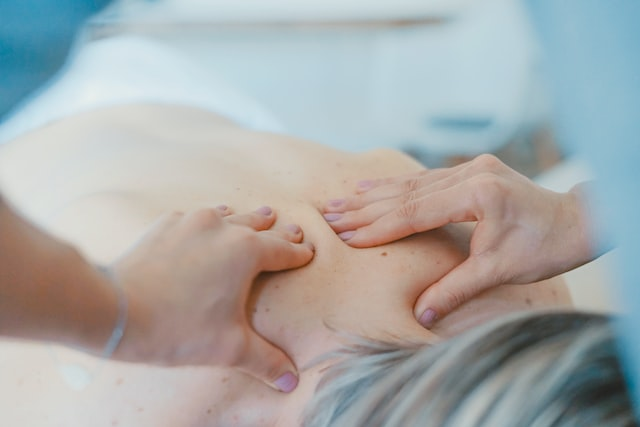 a massage therapist giving a person a massage on their back