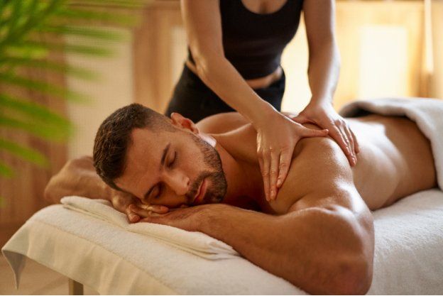 a masseur massaging a man’s back