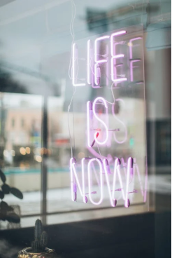 An image of a neon pink sign on a glass at a storefront