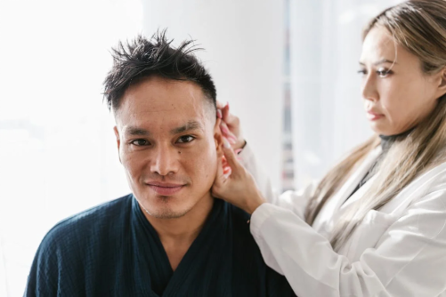  An image of a woman massaging a man’s ears  