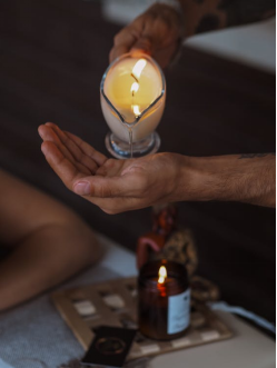 An image of a massage therapist pouring massage oil in their palm 