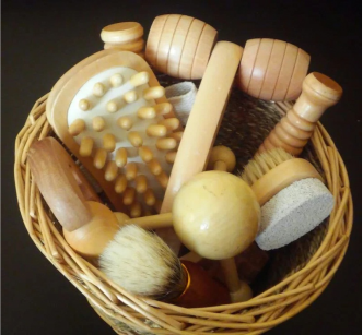 An image of a variety of wooden massage tools in a bamboo basket 
