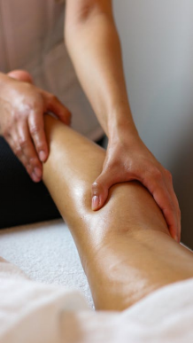 An image of a woman massaging a person’s legs 