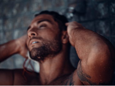 An image of a shirtless man taking a shower