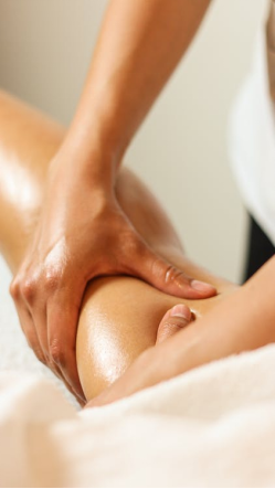 An image of a woman massaging a man’s legs with her hands 