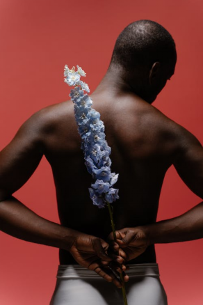 A person holding a flower behind their back