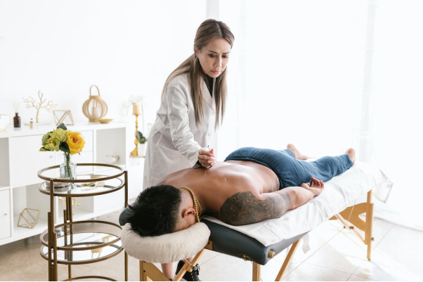 A massage therapist applying pressure on a client’s back