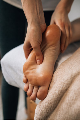 An image of a woman massaging a man’s foot 