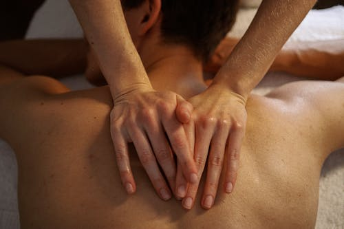 Man getting massaged by a woman.