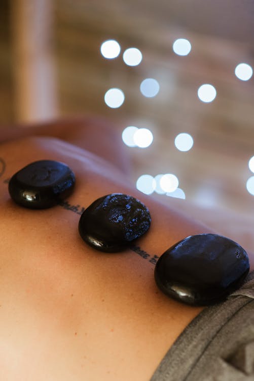 Person receiving a hot stone massage on their back